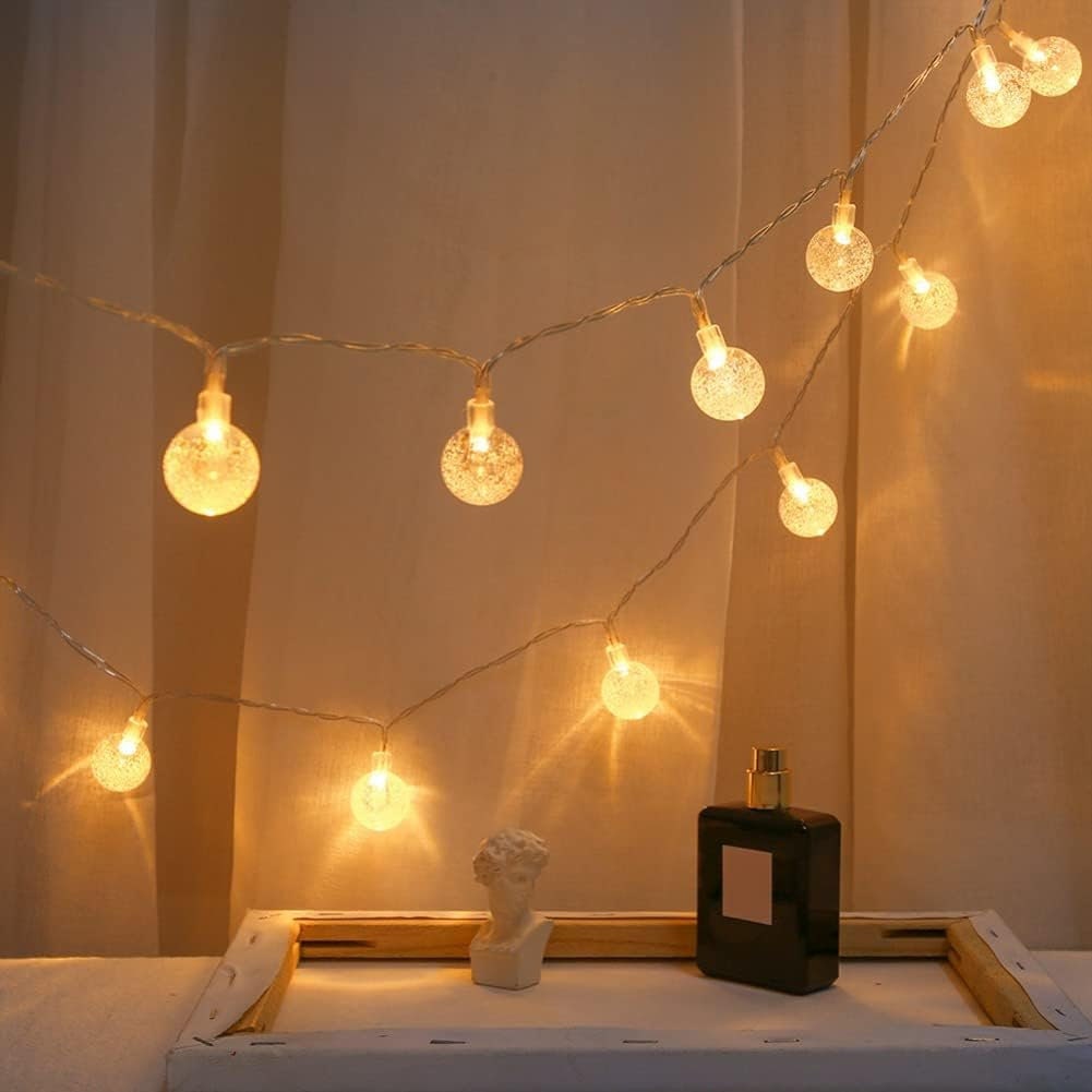 A light chain in the shape of crystal balls hangs on curtains, giving warm atmosphere