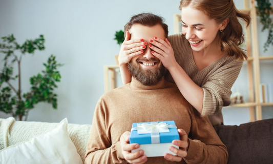 Woman surprising her boyfriend with a thoughtful gift, showcasing a heartfelt moment of love and appreciation.