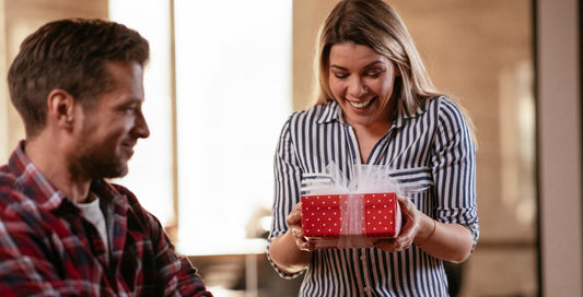 A man gifting his girlfriend or wife a thoughtful Valentine's Day gift, showcasing love and affection.