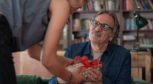 Daughter giving her father a personalized Father's Day gift, with the father looking happy and touched