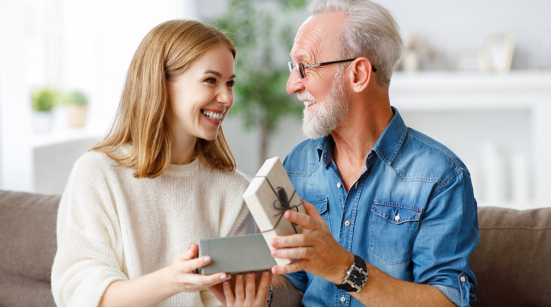 Eine Tochter übergibt ihrem Vater ein persönliches Geburtstagsgeschenk.