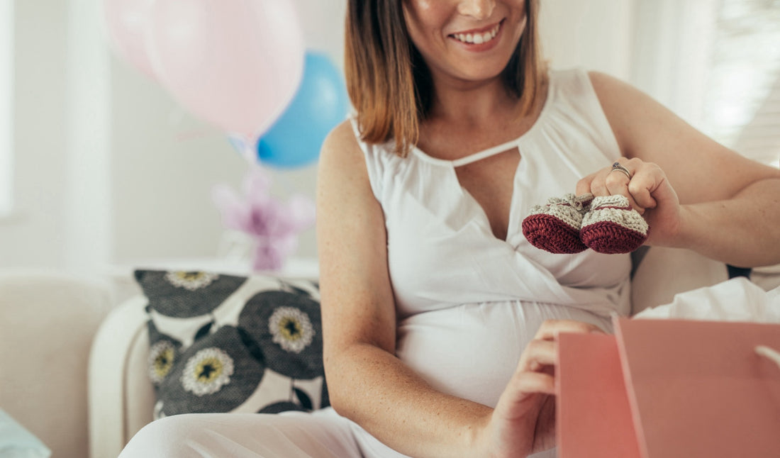 Mother receiving a beautifully wrapped personalized gift for her newborn, symbolizing love and thoughtfulness during a special baby shower celebration.