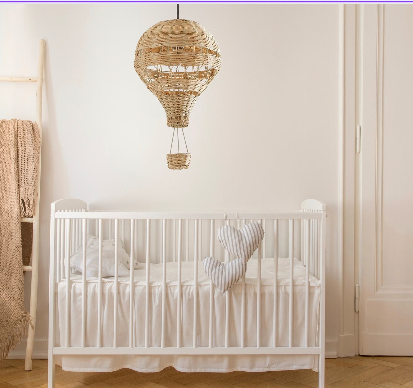 A hand-woven hot air balloon lamp made of bamboo, beautifully displayed in a simple babys room
