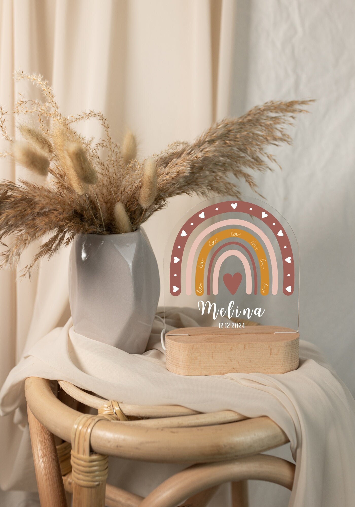 Children's night light featuring a rainbow motif and personalized with a name and birth date, captured in daylight against a boho-style background.