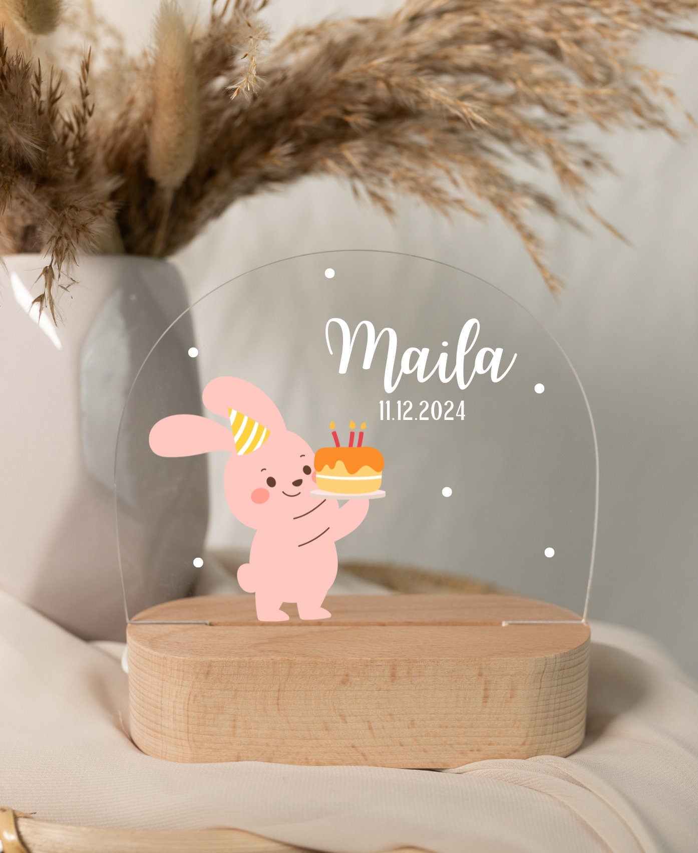 Close-up view of a baby night light with a rabbit motif, illuminated by daylight and set against a boho-style background.