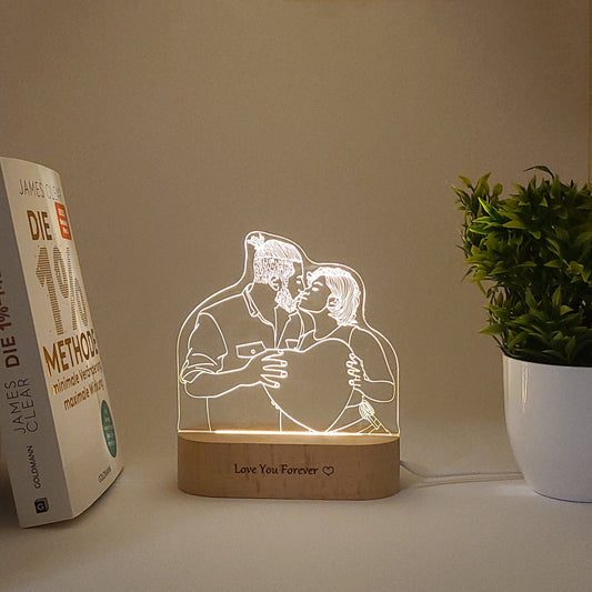 Custom LED photo lamp featuring a couple kissing, illuminated on a desk in a dark setting.