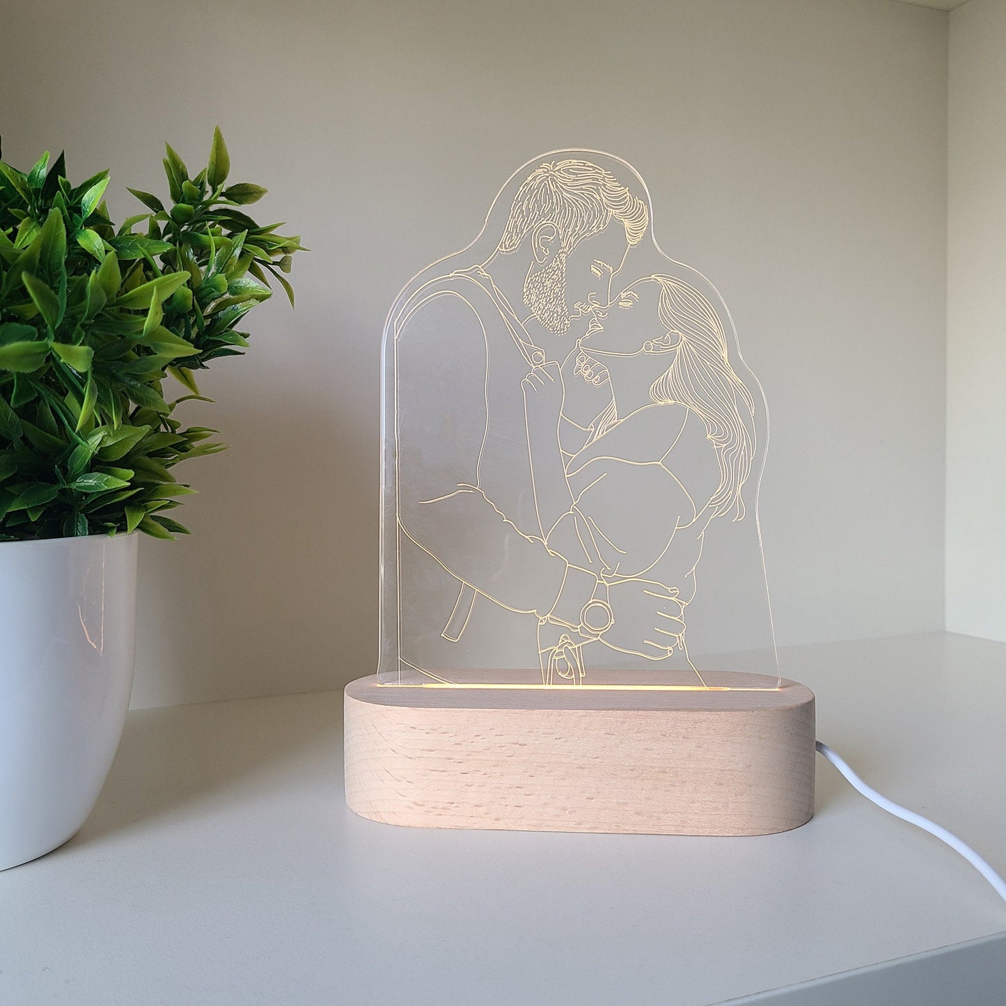 Individual 3D photo lamp depicting a couple embracing in daylight, placed on a desk with close up view