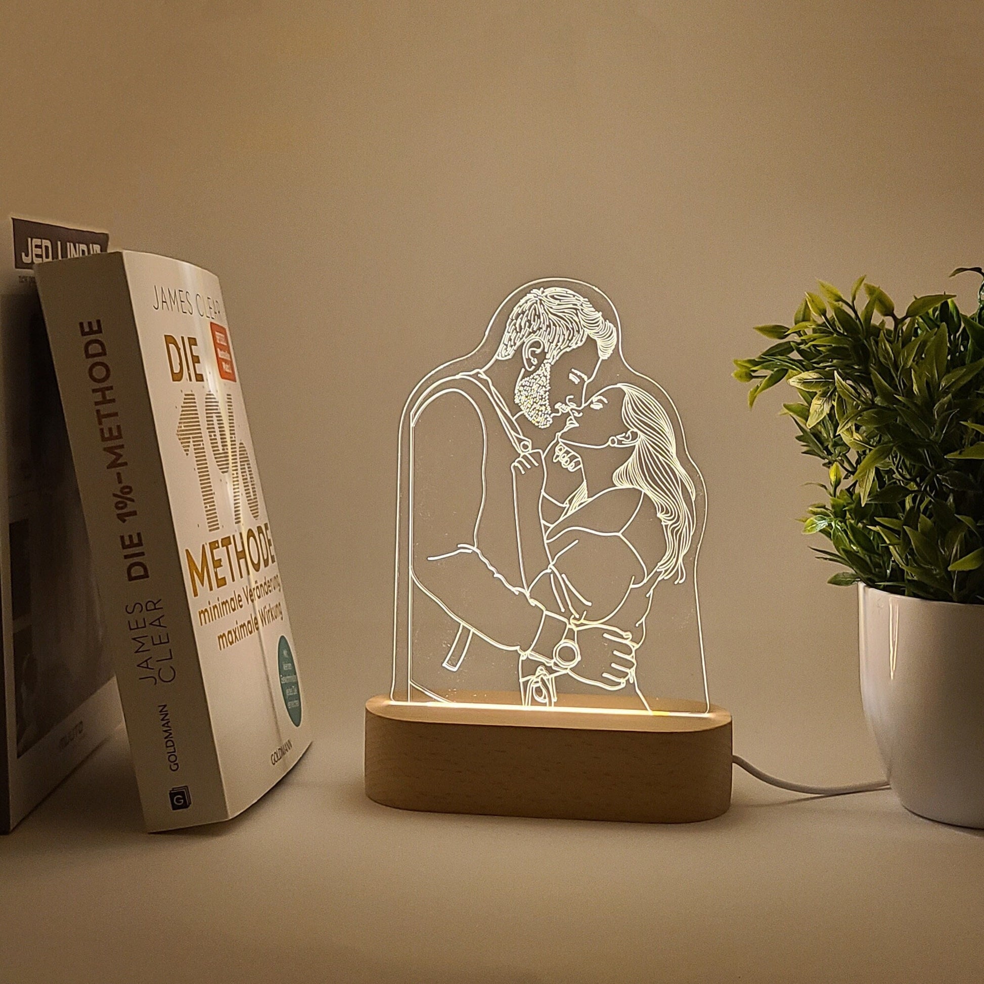 Individual 3D photo lamp depicting a couple embracing in soft lighting, placed on a desk.