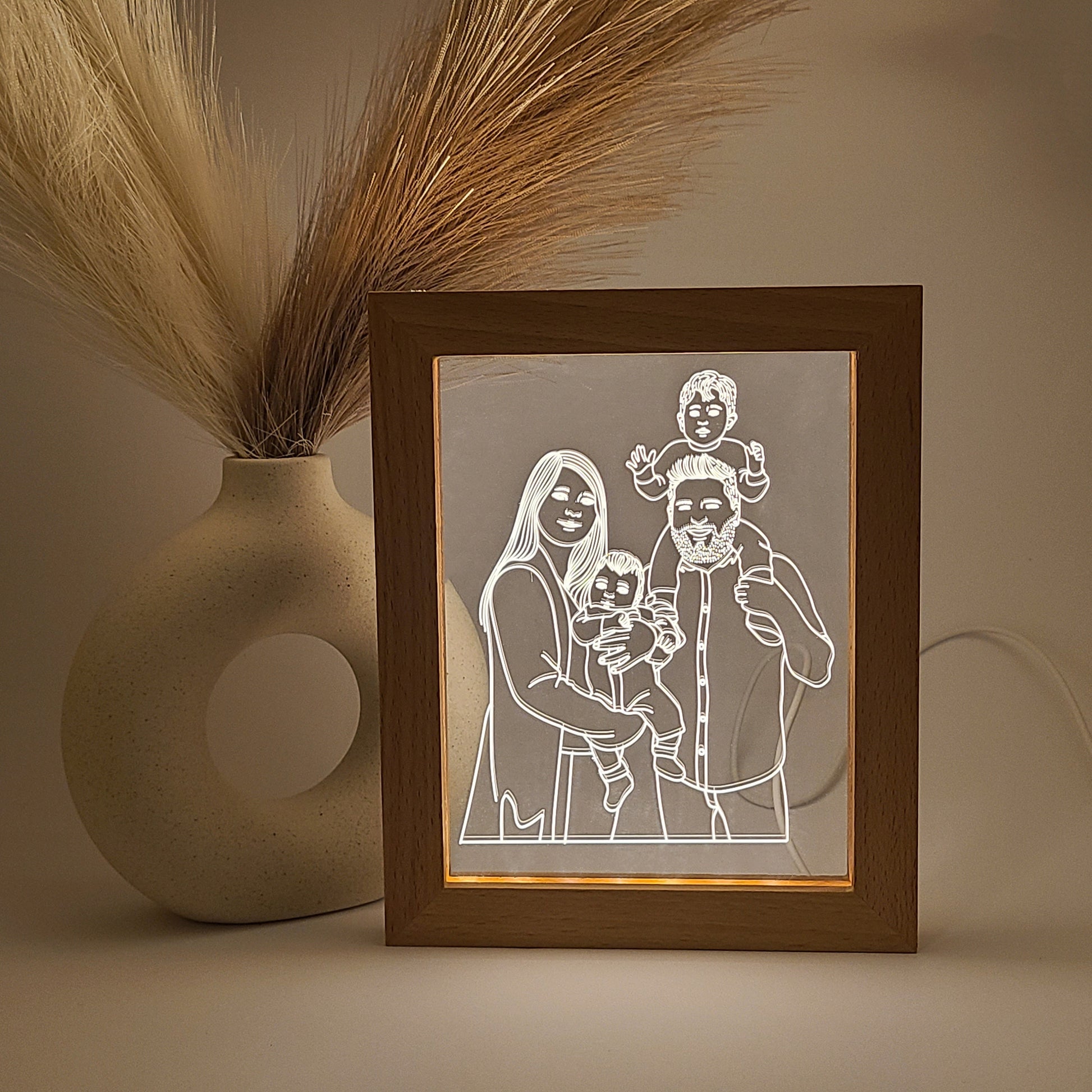 Personalized photo frames featuring an engraved family photo, displayed in low light and close-up view