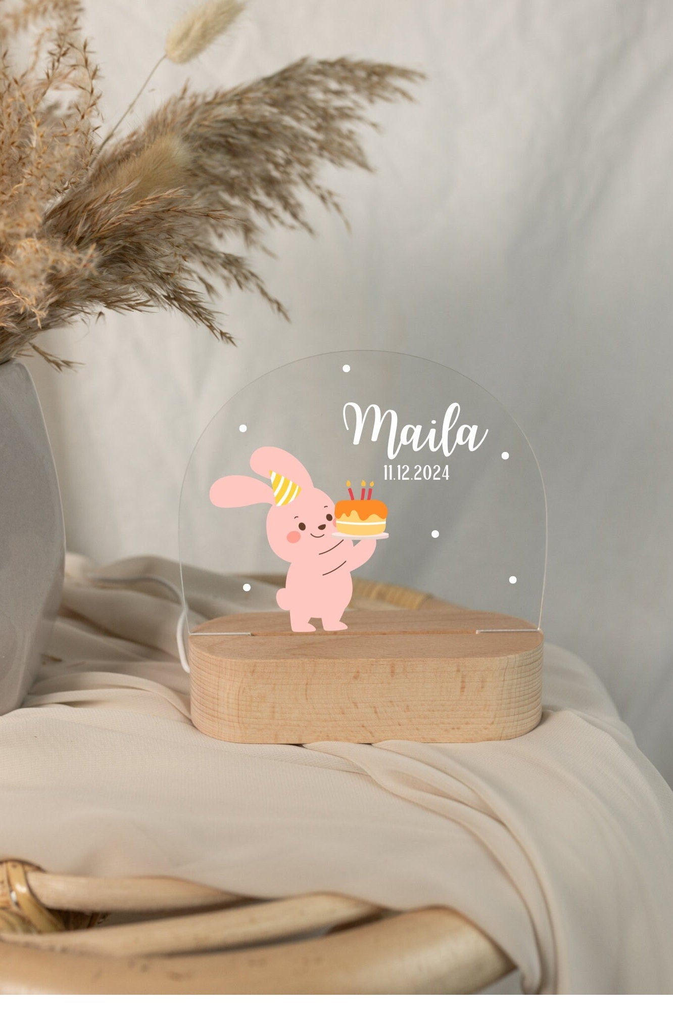 Pink baby night light featuring a rabbit motif, captured in daylight with a close-up view against a boho-style background.