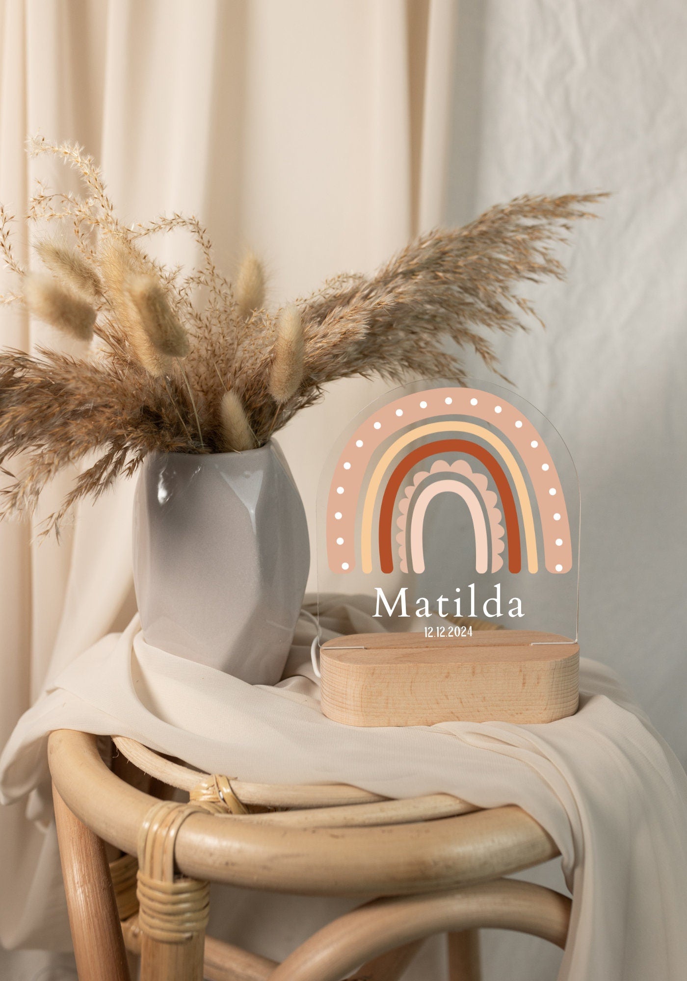 Rainbow baby night light personalized with a name and birth date, captured in daylight against a boho-style background.