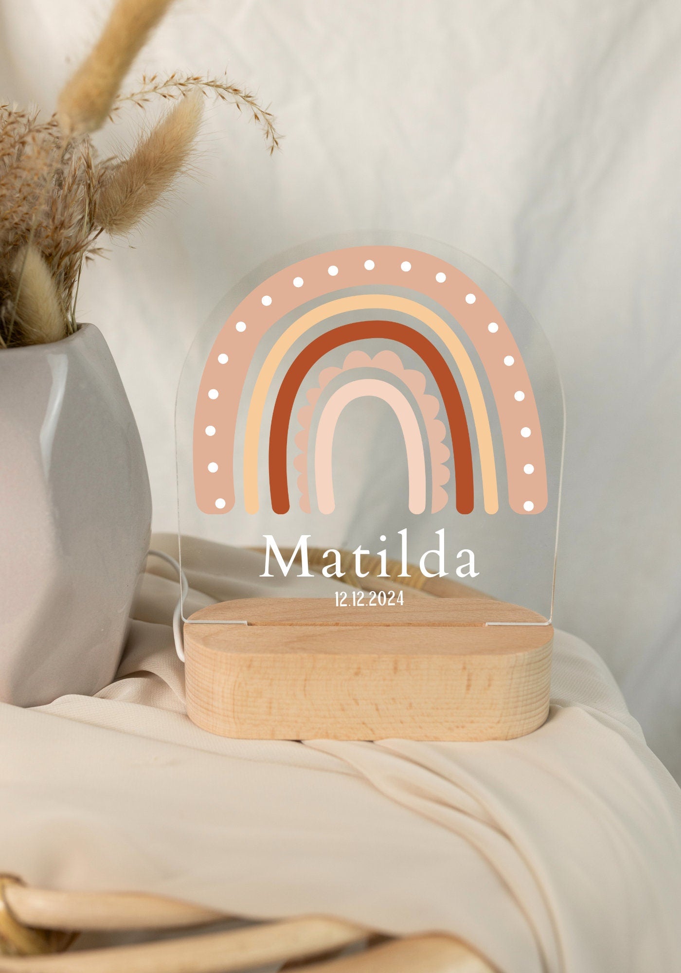 Rainbow baby night light personalized with a name and birth date, captured in daylight with a close-up view against a boho-style background.