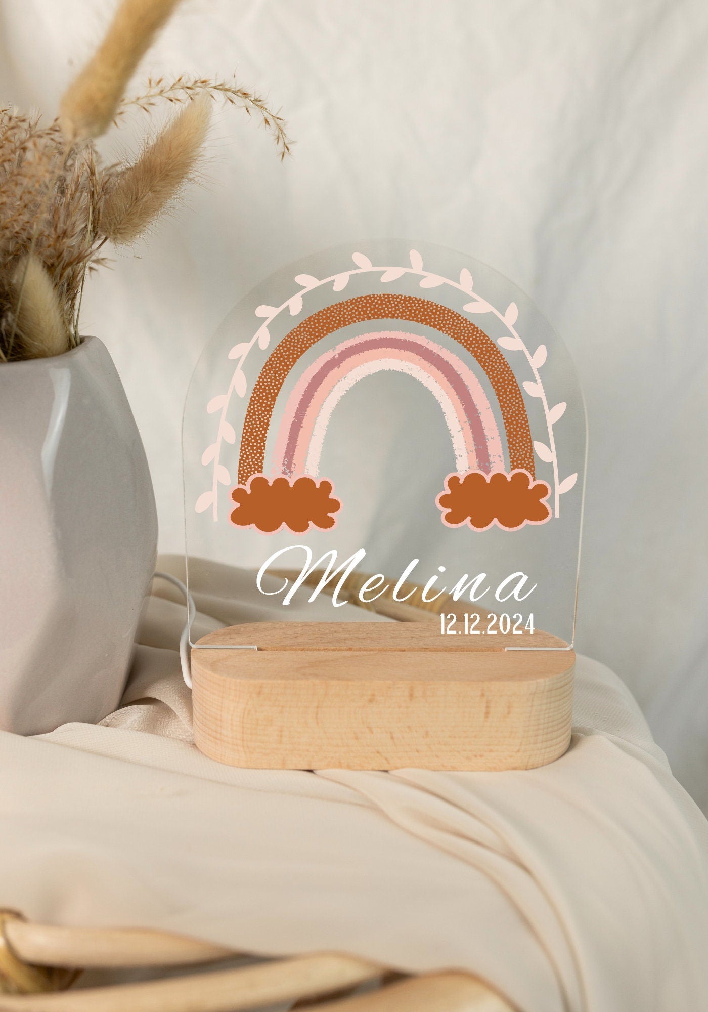Rainbow night light personalized with a name and date of birth, captured in daylight with a close-up view against a boho-style background.