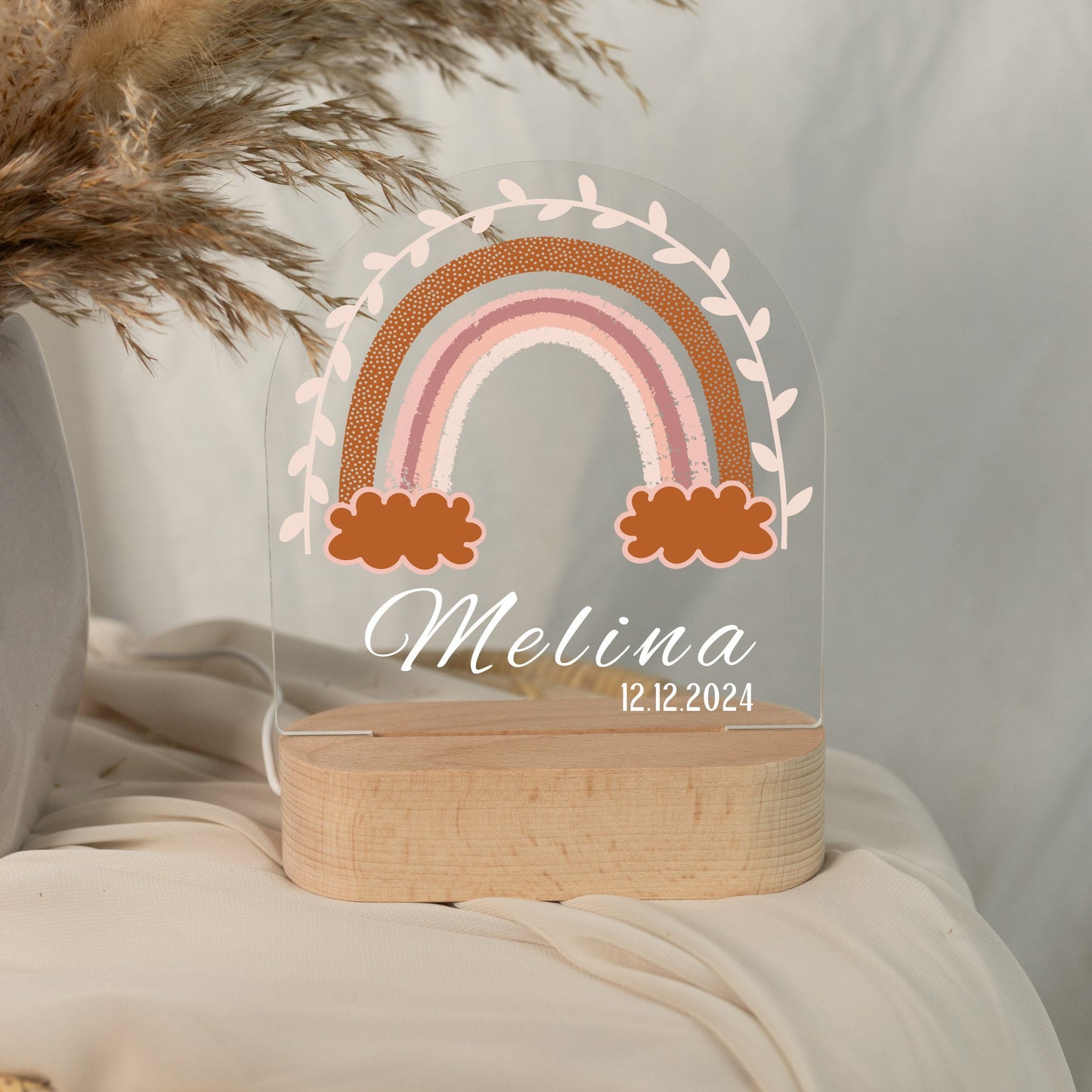Rainbow night light personalized with a name and date of birth, photographed in daylight with a close-up view.