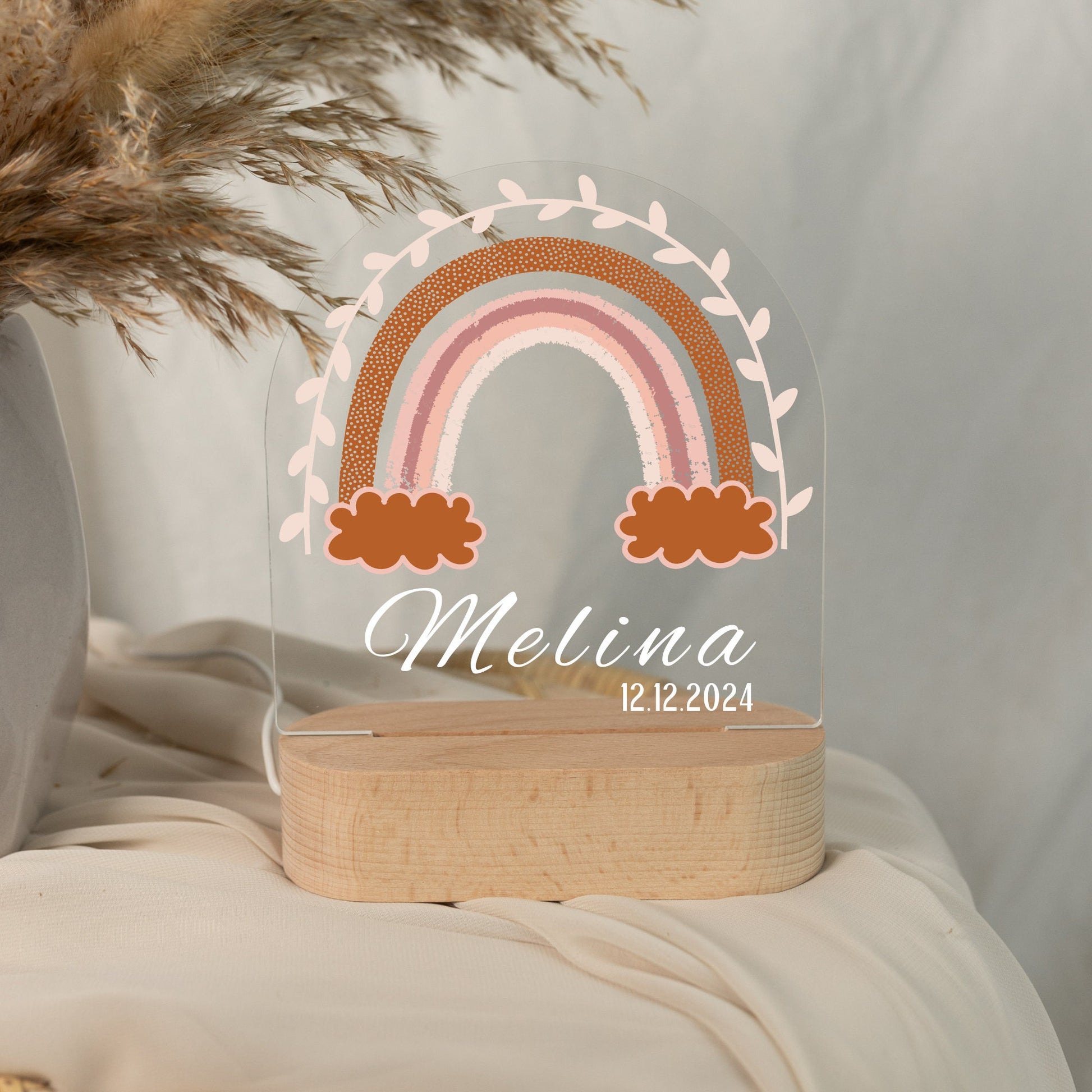 Rainbow night light personalized with a name and date of birth, photographed in daylight with a close-up view.